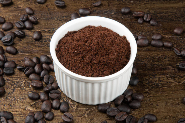 Pečená kávová zrna v prášku v bílé misce. Rustikální pozadí - Fotografie, Obrázek
