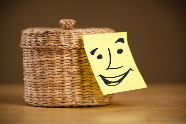 Post-it-Zettel mit Smiley-Gesicht auf Schachtel geklebt - Foto, Bild