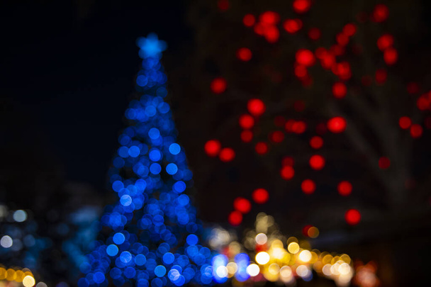 abstrakter Weihnachtsbaum und festliche Lichtergirlanden Beleuchtung unfokussierte Feiertage Konzept Bild in der Nacht - Foto, Bild
