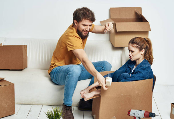 família jovem casal no sofá divertido mover caixas com coisas - Foto, Imagem