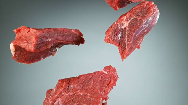 Raw beef steaks flying up in the air - Foto, Imagen