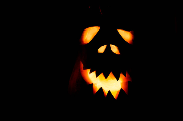 Böses Kürbisgesicht zu Halloween in einem dunklen Raum in Großaufnahme. - Foto, Bild