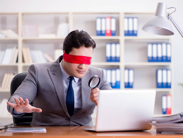Blinddoek zakenman zit aan bureau in het kantoor - Foto, afbeelding