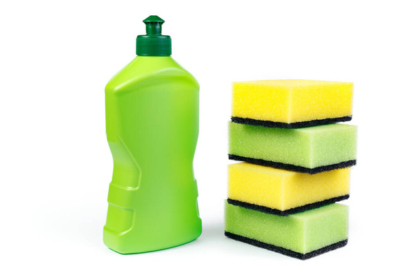 Bottle of dishwashing detergent and colorful sponges on white background. - Фото, изображение
