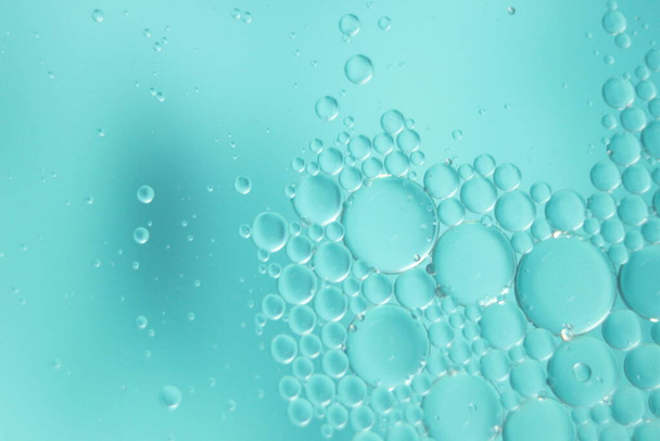 fondo macro abstracto de círculos de petróleo flotando sobre la superficie del agua. Macro vista de cerca de burbujas en el agua. burbujas de aceite en el agua macro fondo fotográfico - Foto, Imagen