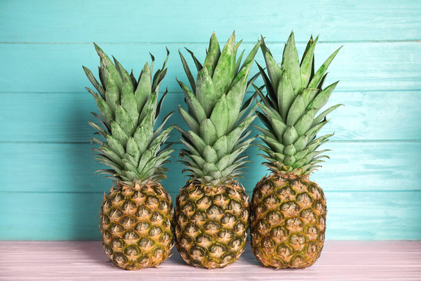 Fresh ripe juicy pineapples on pink wooden table - Photo, Image