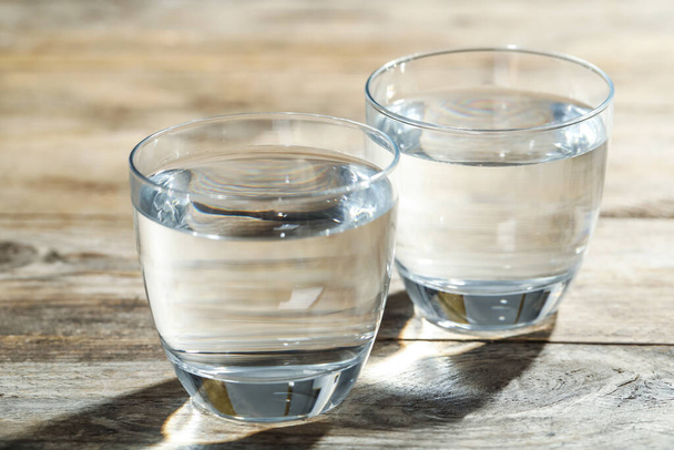 Ποτήρια νερού σε ξύλινο τραπέζι. Δροσιστικό ποτό - Φωτογραφία, εικόνα