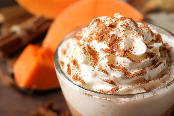 Delicious pumpkin latte with whipped cream on table, closeup - Foto, afbeelding