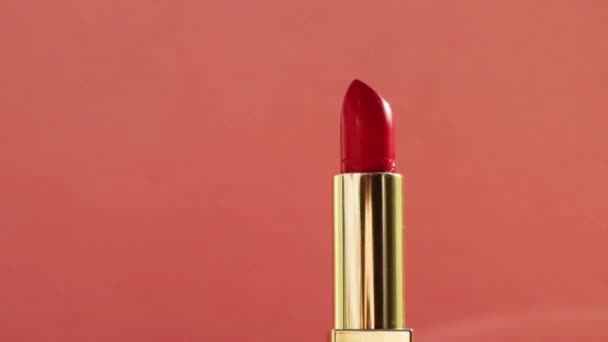 Lápiz labial rojo chic en tubo dorado y destellos de luz brillante, producto de maquillaje de lujo y cosméticos de vacaciones para la marca de belleza - Imágenes, Vídeo