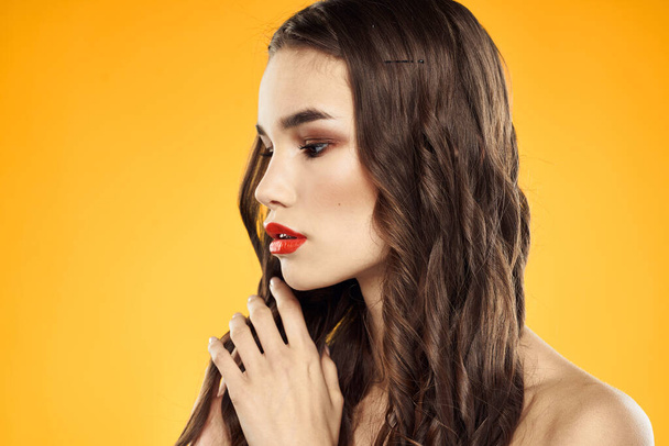 Femme aux épaules nues rouge lèvres coupées charme fond jaune - Photo, image