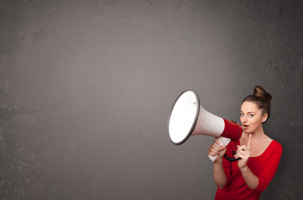 Girl shouting into megaphone on copy space background - Photo, Image