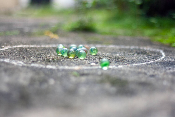 Juego tradicional malayo Guli, un juego jugado con pequeñas bolas de vidrio redondas llamadas canicas. - Foto, Imagen