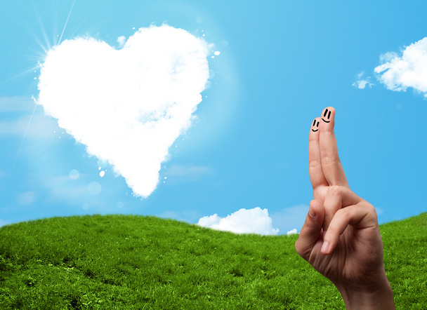 Onnellinen hymiö sormet katsomalla sydämen muotoinen pilvi - Valokuva, kuva