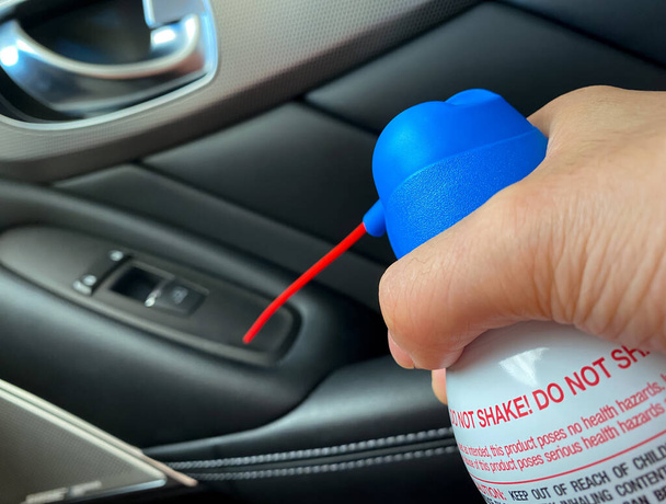 Close up άποψη του χεριού κρατώντας το ξεσκονόπανο αέρα και τον καθαρισμό των κουμπιών της πόρτας στο αυτοκίνητο - Φωτογραφία, εικόνα