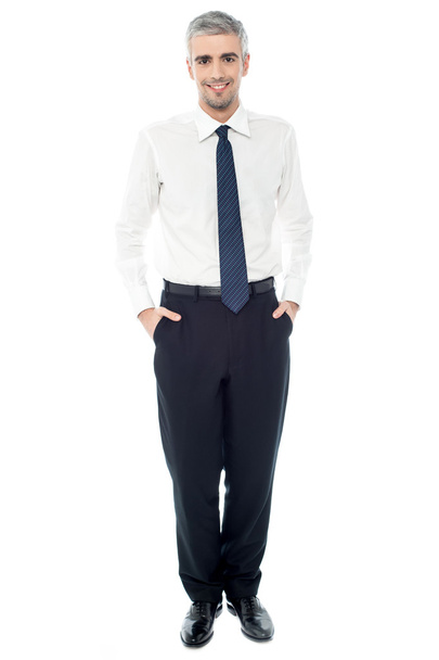 Confident businessman with hands in pockets - Foto, afbeelding