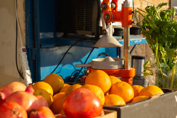 Гранаты и апельсины в магазине с соковыжималкой - Фото, изображение