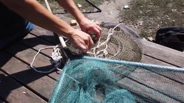 Mannelijke handen zijn vingeren controleren visserij accessoires aan te pakken op oude houten tafel - Video