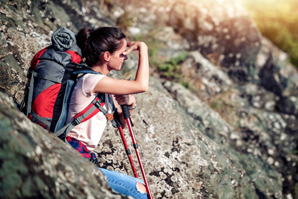 Young woman hiking through mountain with hiking sticks. - Photo, Image