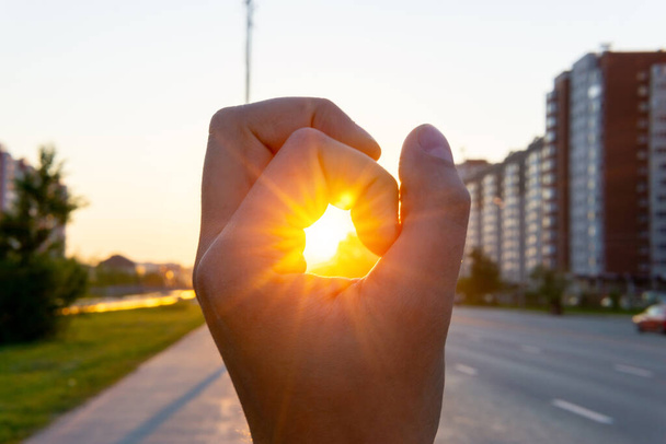 людина рука на фоні ранкового сходу сонця в місті, міський пейзаж. вибірковий фокус
 - Фото, зображення