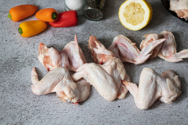 Rauwe kippenvleugels vlees op grijze achtergrond - Foto, afbeelding