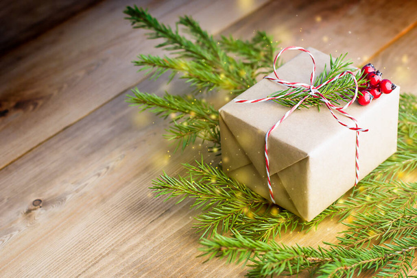 Noel hediyesi ve ahşap masada köknar dalları - Fotoğraf, Görsel