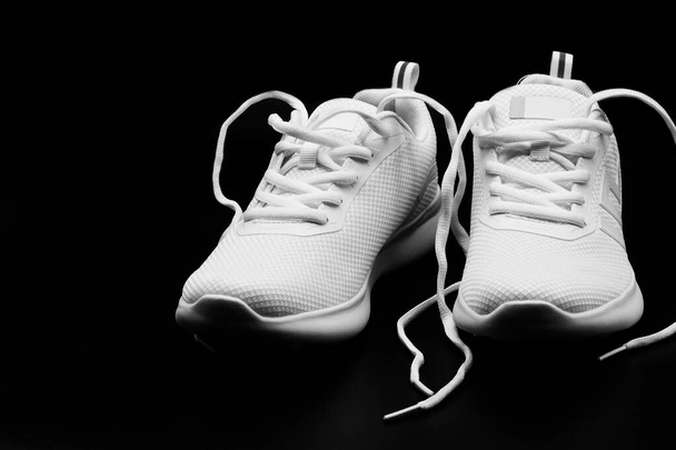 ізольована пара абсолютно нової жінки білі кросівки на чорному фоні
 - Фото, зображення