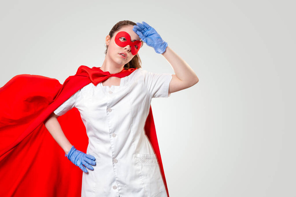 Tired doctor wearing facemask, gloves and superhero cape during coronavirus outbreak. Virus and illness protection, quarantine. COVID-2019. Concept of Super hero power for medicine and stress at work. Copy space. - Valokuva, kuva