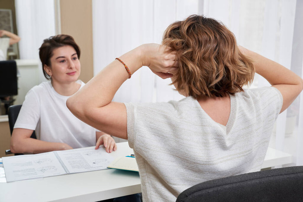 Médico ou especialista em massagem consultoria jovem mulher sobre dor de cabeça - Foto, Imagem