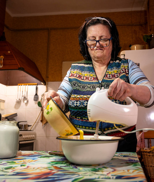 Conceito de cozedura. Senior mulher assar bolo caseiro em casa - Foto, Imagem