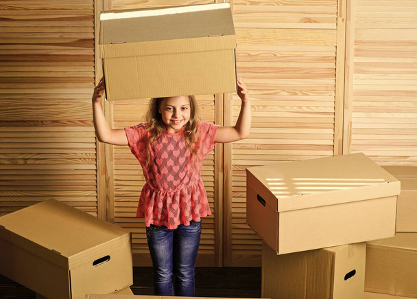 Relocating concept. Delivery service. Box package and storage. Small child prepare for relocation. Relocating family can be exciting, but also stressful for kids. Kid girl relocating boxes background - Fotó, kép