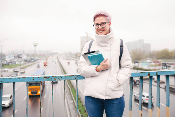 Portrait of young happy blogger with modern laptop and copybooks outdoors    - Фото, зображення