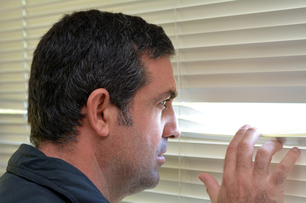 Hombre mirando a través de persianas - Foto, Imagen