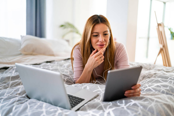 Onnellinen nainen kannettavan tietokoneen kanssa kotona. Teknologia, ihmisten käsite - Valokuva, kuva