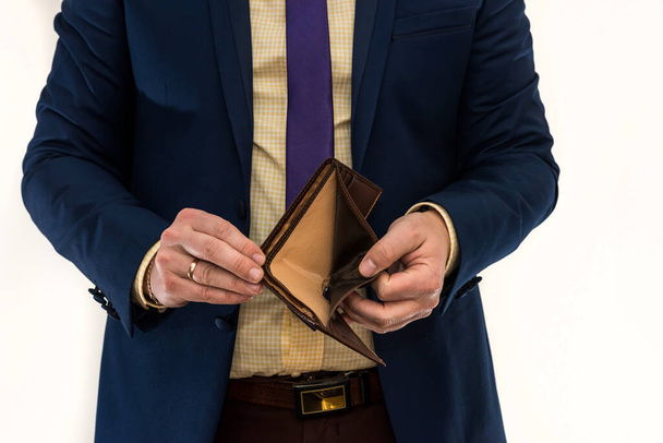 Businessman holding an empty wallet. Despair and failure. Misery. Bankruptcy or poverty concept - Фото, зображення