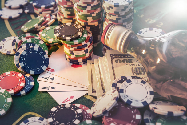 Dollar biljetten, casino chips en whisky glas op tafel. Gokken spel en entertainment concept. - Foto, afbeelding