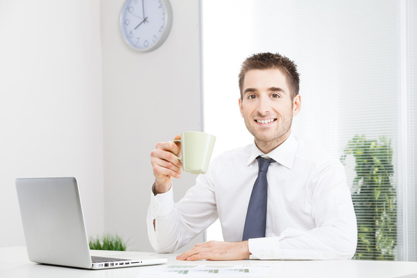 Businessman working on computer and drinking coffee - Photo, Image