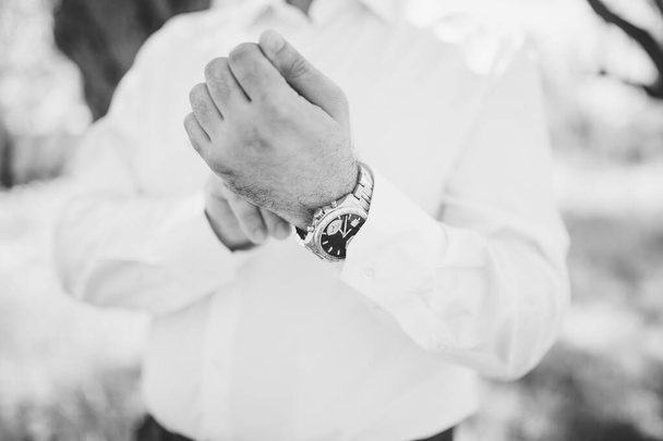 the groom fastens the watch on his wrist - Fotografie, Obrázek