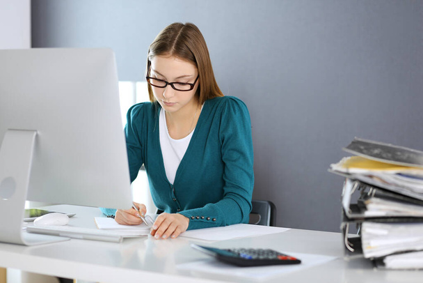 Accountant checking financial statement or counting by calculator income for tax form, hands close-up. Business woman sitting and working at the desk in office. Audit concept - Foto, imagen