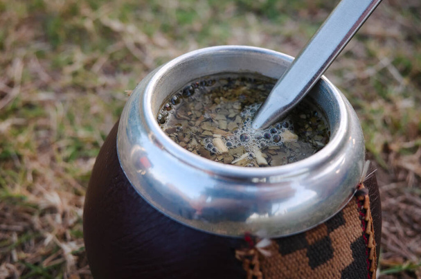 Traditional hot drink in South America called mate in traditional Calabash with gourd with metal straw (bombilla). Made with yerba mate leaves and hot water. Argentina - Photo, Image