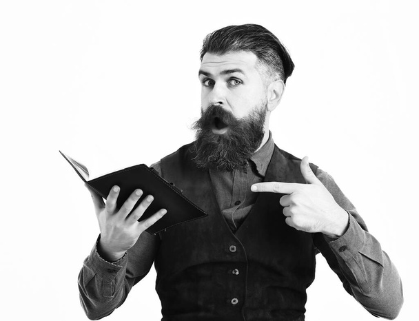 bearded man holding notepad with surprised face - Foto, afbeelding