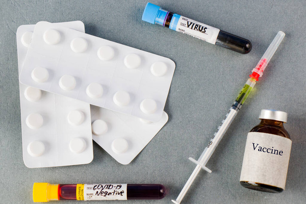 Вакцина ампула, игла, лекарства и трубки крови на сером фоне, вирусная вакцина - Фото, изображение