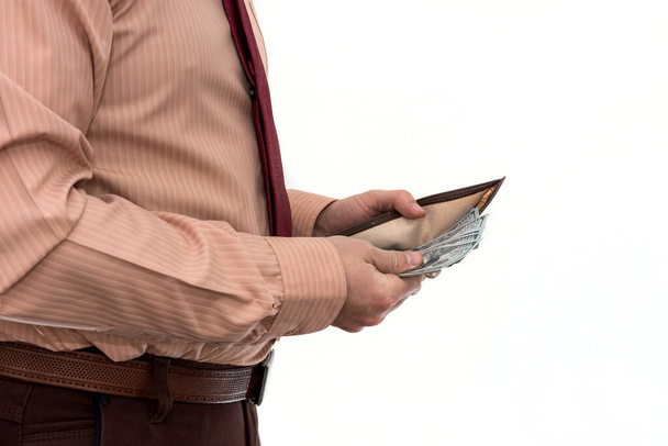 Takım elbiseli bir işadamı bize cüzdandan izole edilmiş para getiriyor. İçinde Amerikan dolarları olan siyah deri bir cüzdan tutan erkek eller. İş, finans ve para kavramı - Fotoğraf, Görsel