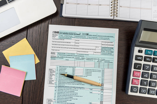 Фінансова податкова форма з калькулятором, ноутбуком і ручкою. Наклейка потребує допомоги. Час обліку
 - Фото, зображення