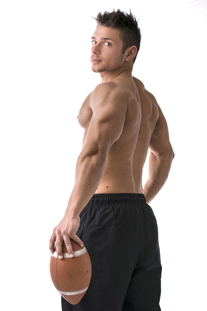 Muscular american football player standing with ball in hand - Fotoğraf, Görsel