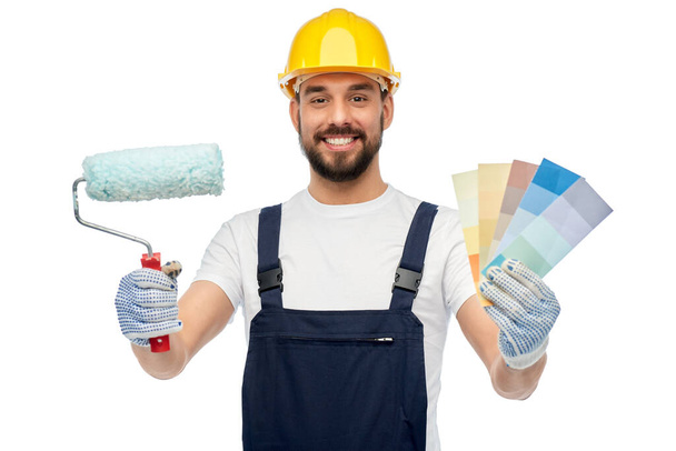 male builder with paint roller and color palettes - Fotografie, Obrázek