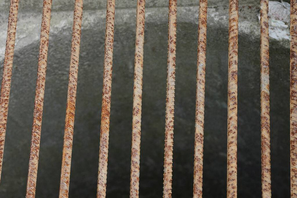 metalowa faktura z żelaznych, zardzewiałych brązowych kratek na studni ściekowej z szarego betonu - Zdjęcie, obraz