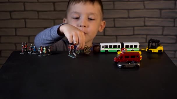 Shooting of four year old kid playing with tin soldiers and cars - Footage, Video