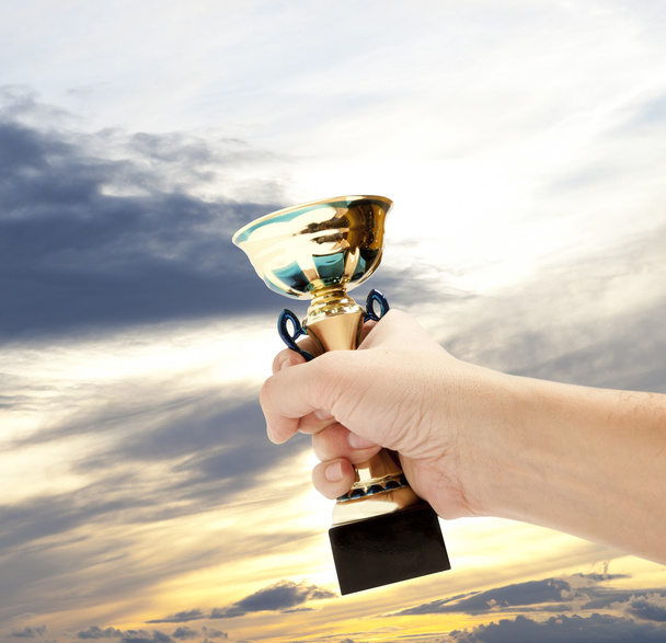 Ouro Copa vencedor contra o céu azul
 - Foto, Imagem