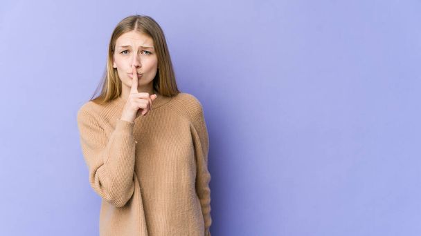Young blonde woman isolated on purple background keeping a secret or asking for silence. - Photo, Image