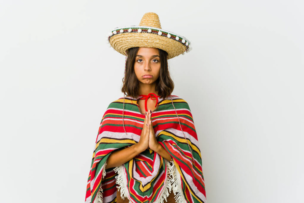 Nuori meksikolainen nainen eristyksissä valkoisella pohjalla rukoilemassa, osoittamassa kiintymystä, uskonnollinen henkilö etsii jumalallista inspiraatiota. - Valokuva, kuva